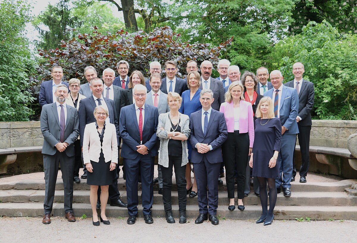 Bild: Die Teilnehmer*innen der 77. Jahrestagung der OLG-Präsidenten stehen während Ihrer Jahrestagung in einem Park in Weimar