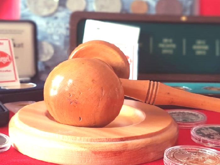 Bild: Schreibtisch, beispielsweise eines Gerichtsvollziehers, mit einem Gerichtshammer, Gesetzestext und Geldstücken