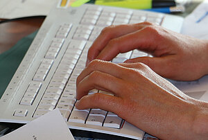 Tastatur mit aufgelegten Händen