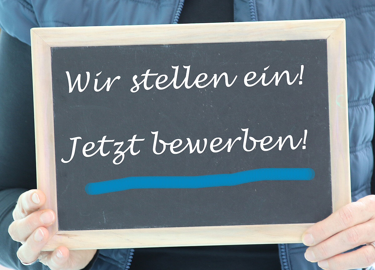 Tafel mit der Aufschrift "Wir stellen ein! Jetzt bewerben!"