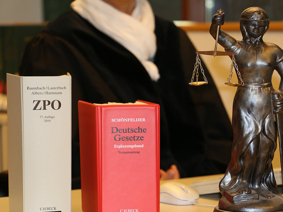 Bild: Gesetzestexte mit nebenstehender Justitia
